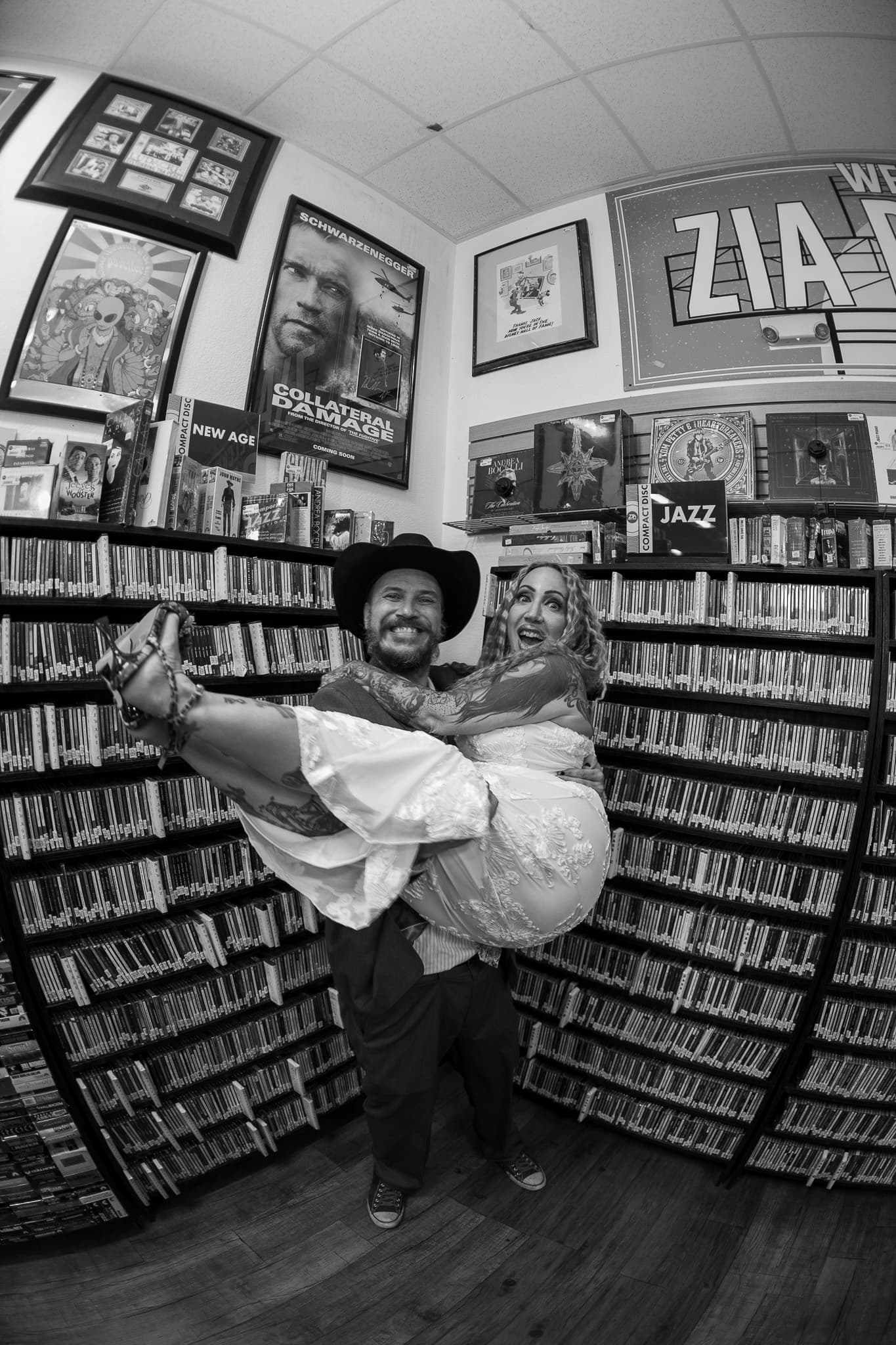 Groom carrying his bride through a Las Vegas record store