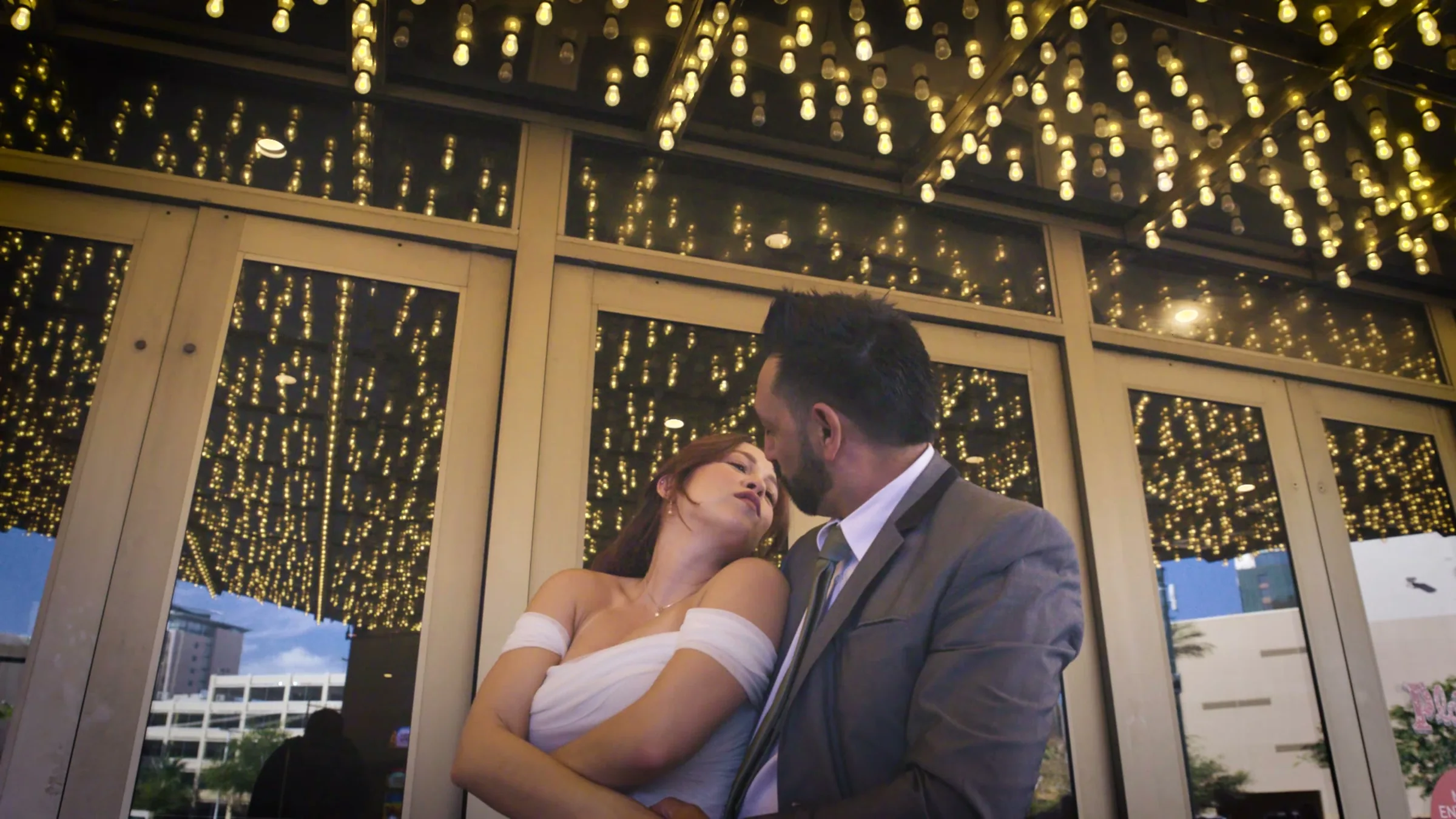 Couple dancing under marquee bulbs