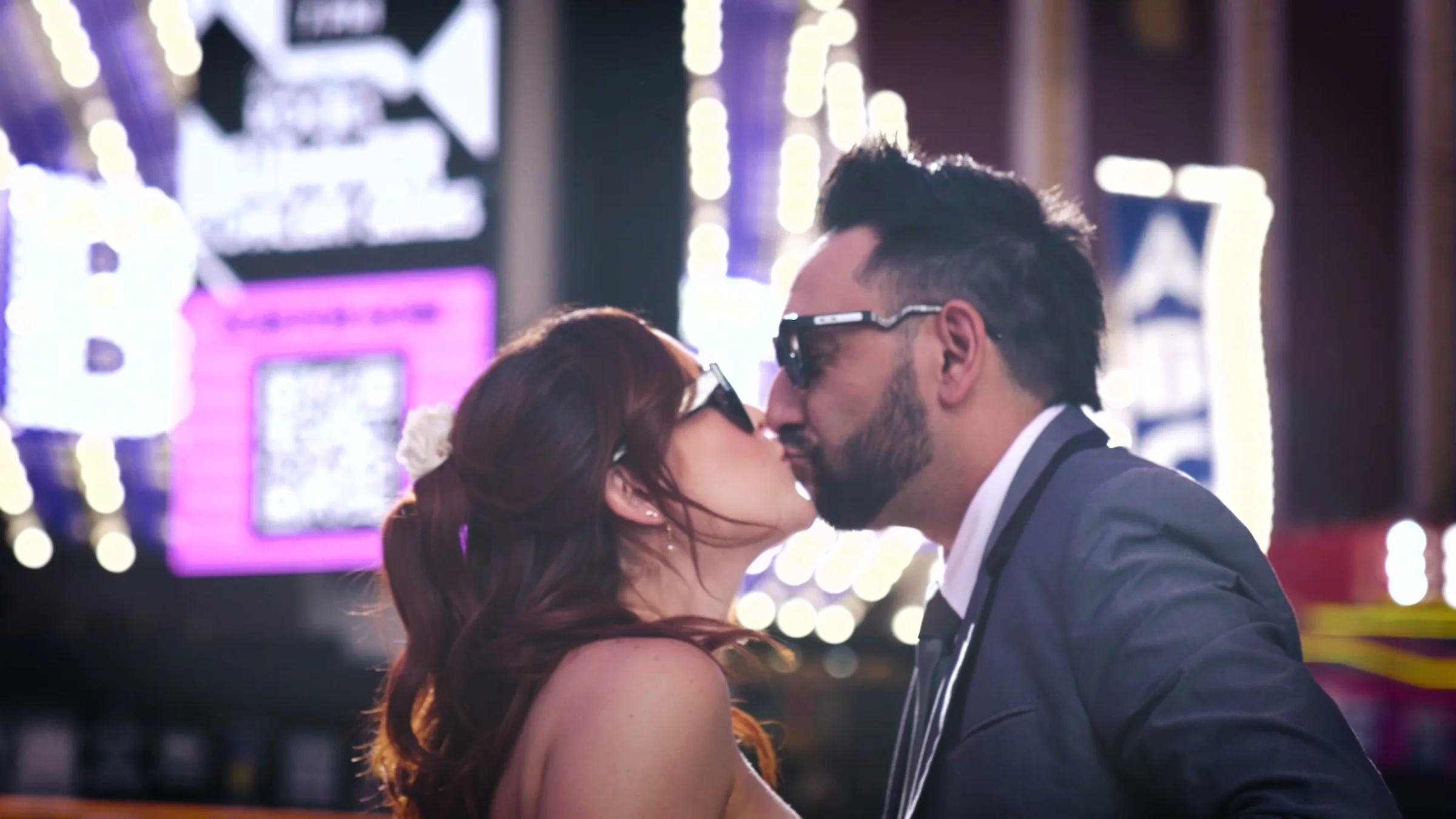 A kiss under neon signs